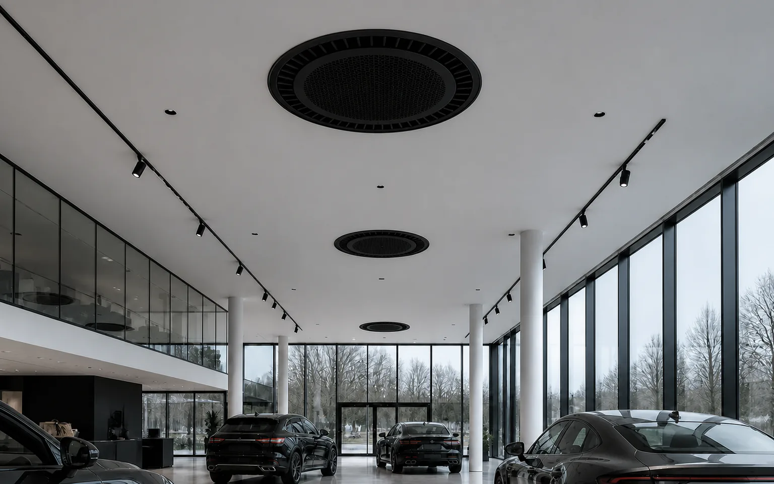 Car showroom with large glass facades, a high space and black round ceiling cassettes